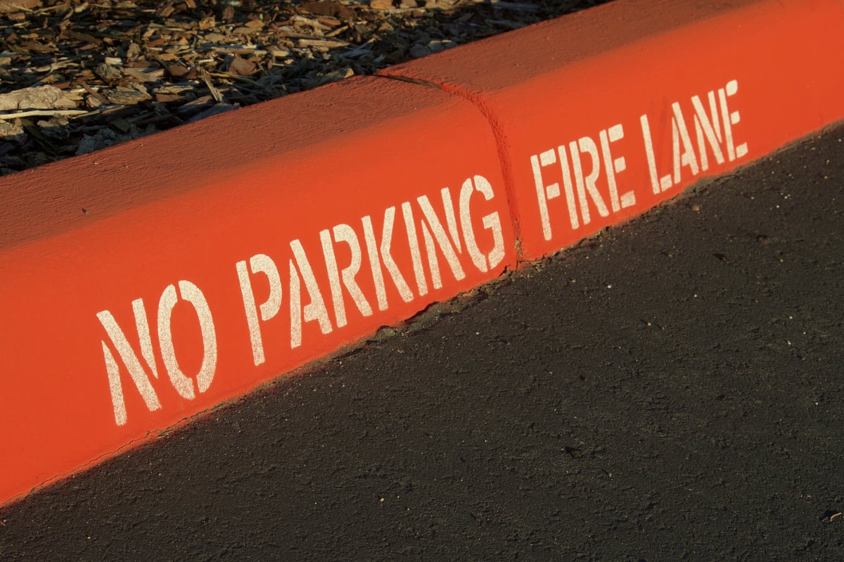 Freshly painted red fire lane curb with no parking marking